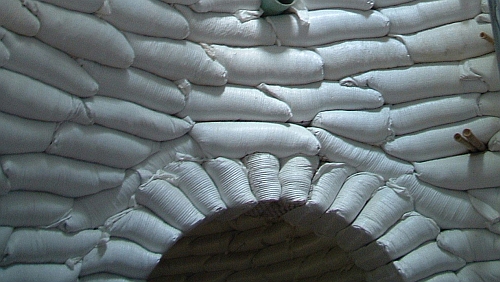 Interior of an earthbag dome: curved plastered walls meeting overhead in a continuous shell.
