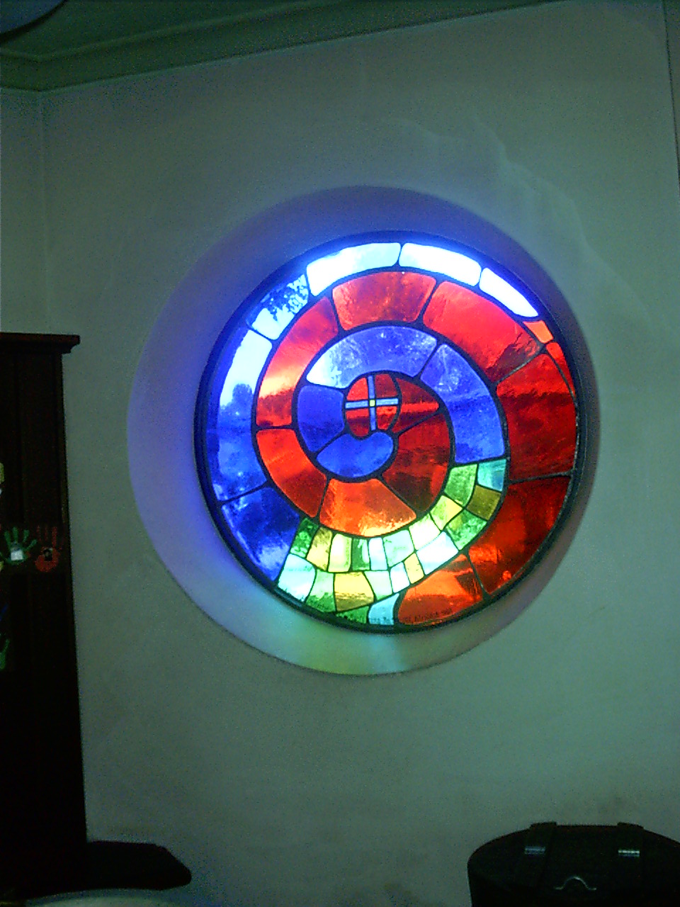 A Hundertwasser stained-glass window in irregular coloured panes.
